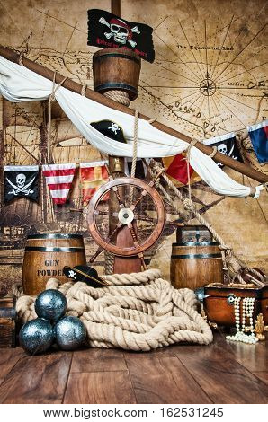 Pirates ship deck with steering wheel and flag.