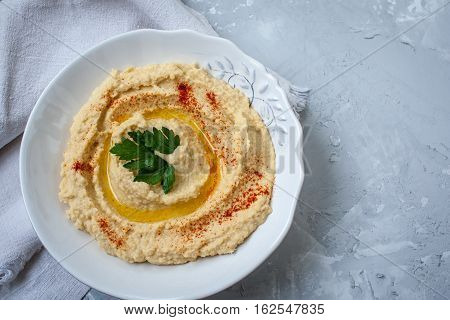 Home classic hummus with celery pitoy.Vid top on gray concrete background. Vegan Food Concept.