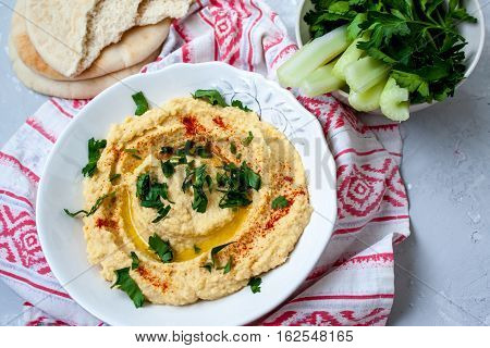 Home classic hummus with celery pitoy.Vid top on gray concrete background. Vegan Food Concept.
