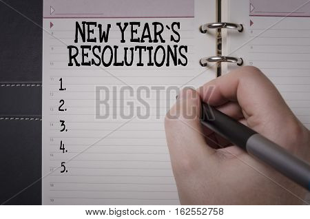 Woman hand writing New Year`s Resolutions. New Year's Resolution concept