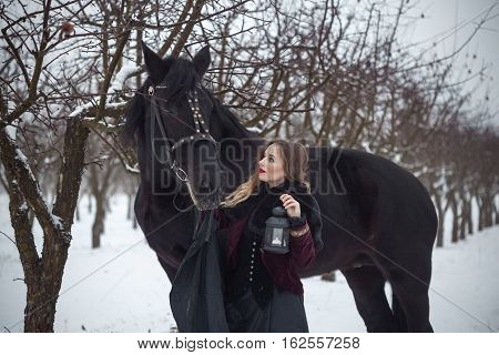 Girl In Dark Clothes With A Black Horse