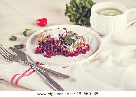 Cherry pie and a cup of tea. Rustic style. Berry pie. Homemade cherry pie with flaky crust cup of coffee bowl with cherries