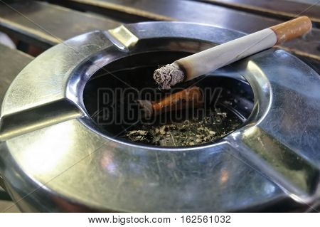 smoking a cigarette, cigarette in ashtray