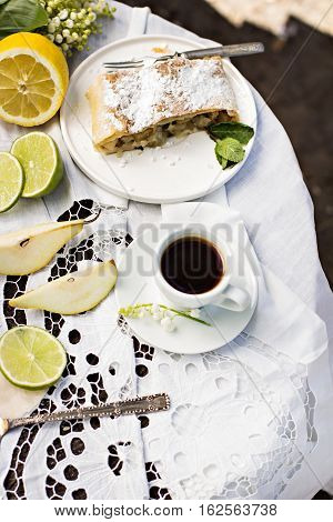 pie strudel with pear and lemon. Cup of coffee. Picnic Breakfast in nature. Food in nature.