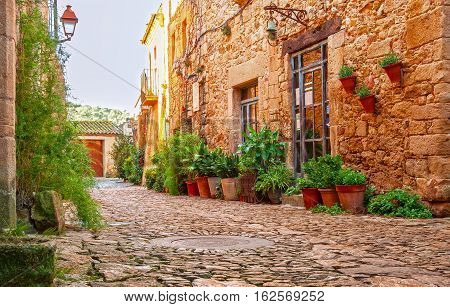 A street in the old town of Peratallada, Catalonia, Spain. Medieval street in the mediaval town in Europe.  Panoramic view of old town  in beautiful evening light at sunset