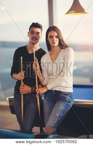 Young couple playing billiard in the cafe
