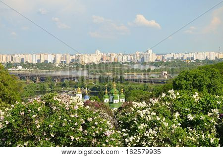 spring day in blossoming lilacs church into phonemes river and big city
