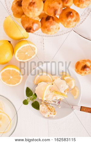 Profiteroles with lemon cream on white dish.