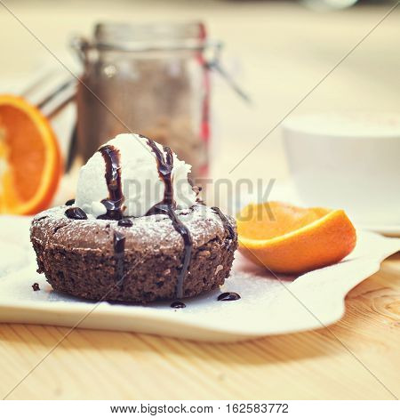 Warm dessert chocolate cake Fondant served on plate with ice-cream ball almond chips mint icing citron cacao