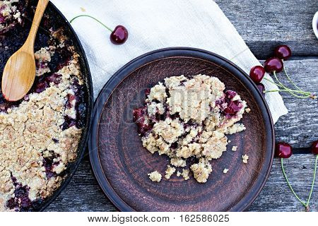 Homemade Cherry crumble and cherries on an old wooden table background.Selective focus.