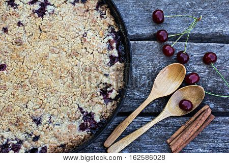 Homemade Cherry crumble and cherries on an old wooden table background.Selective focus.