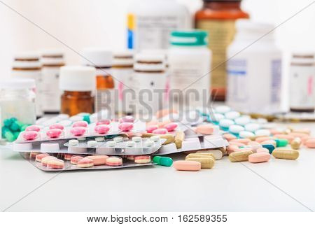 Stack Of Pills And Containers On White Background