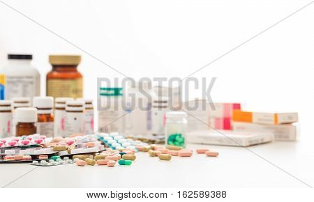 Stack Of Pills And Containers On White Background