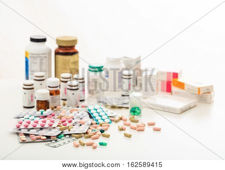 Stack Of Pills And Containers On White Background