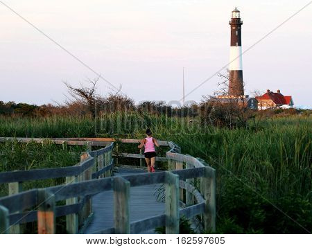 A runner jogs on the boardwalk at The Fire Island Lighthouse
