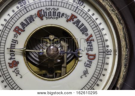 Slightly simplified image of a vintage weather barometer forecasting stormy weather ahead.
