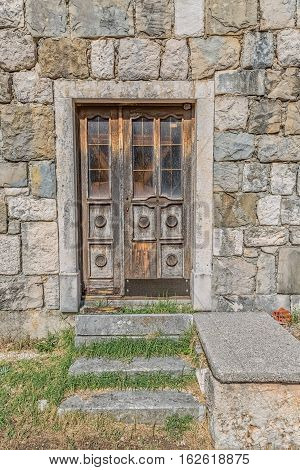 Brown old wooden door of the typical house in Tucepi village, Croatia.
