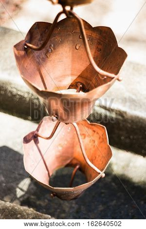 Vintage metallic bells used for rain waters way-out in zen garden stock photo