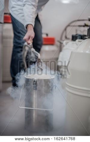 Liquid Nitrogen Technician Fills Cryogenic Container