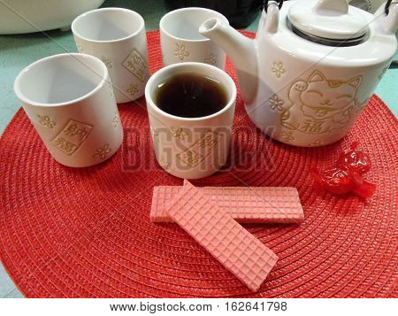 Tea in a Lucky Kitty Teapot and Pink Wafer Cookies