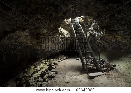 Ladder descending into underground Lave tubes at Lava Beds National Park