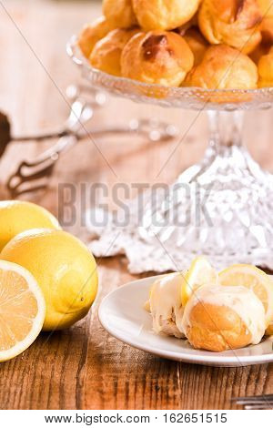 Profiteroles with lemon cream on white dish.