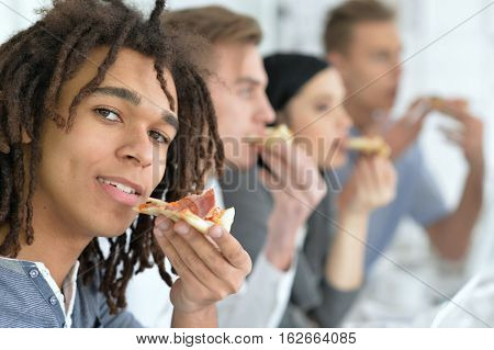 Portrait of people eating pizza in ofiice close-up