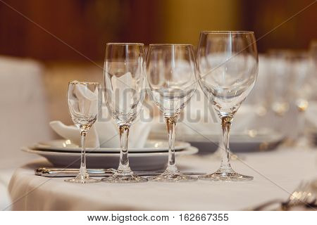 Empty plate glasses and silverware set on white table