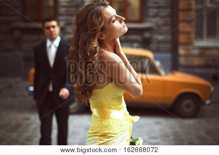 Lady In Yellow Stands Holding Her Nack And Eyes Closed