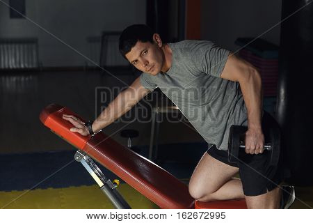 Young Handsome Adult Man Execute Exercise With Dumbbells, On Broadest Muscle Of Back.