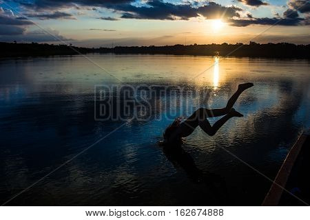 Reflection of the sun at sunset in the Limoncocha lagoon in the Ecuadorian Amazon