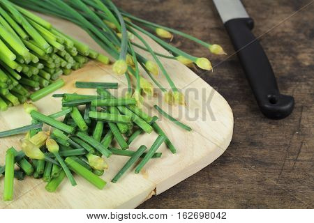 bunch of fresh chives on a wooden cutting board
