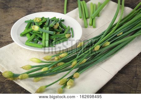 bunch of fresh chives on a wooden cutting board