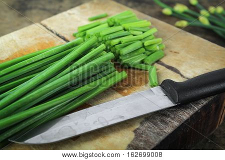 bunch of fresh chives on a wooden cutting board