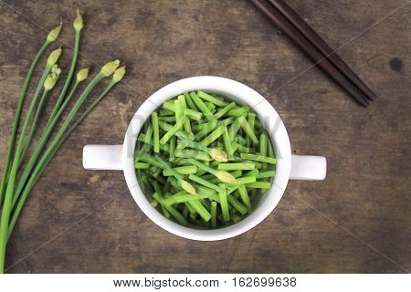 bunch of fresh chives on a wooden cutting board