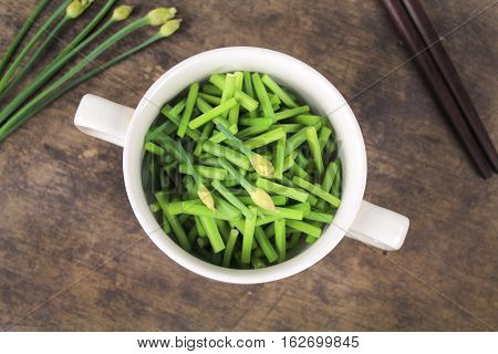bunch of fresh chives on a wooden cutting board