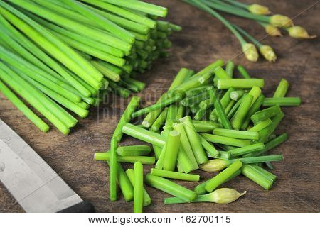 bunch of fresh chives on a wooden cutting board