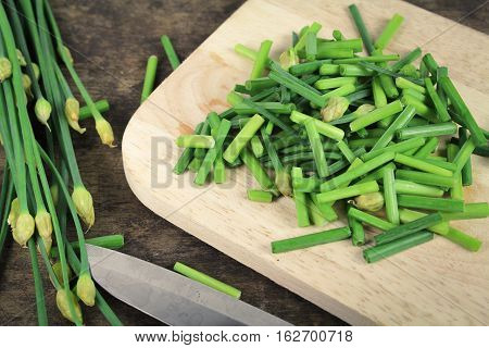 bunch of fresh chives on a wooden cutting board