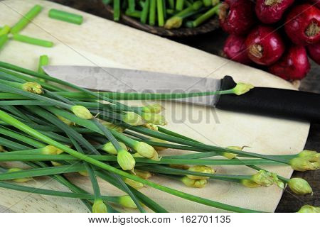 bunch of fresh chives on a wooden cutting board