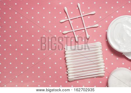facials skin care. cotton pads and buds on the pink backgroung