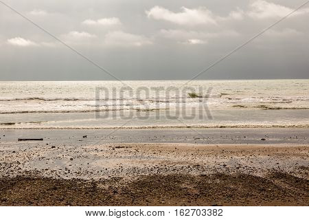 Sunset on the beach rays of light seep through the clouds