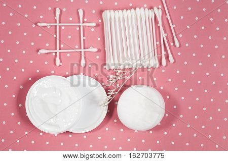 facials skin care. cotton pads and buds on the pink backgroung