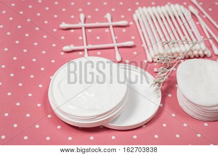 facials skin care. cotton pads and buds on the pink backgroung