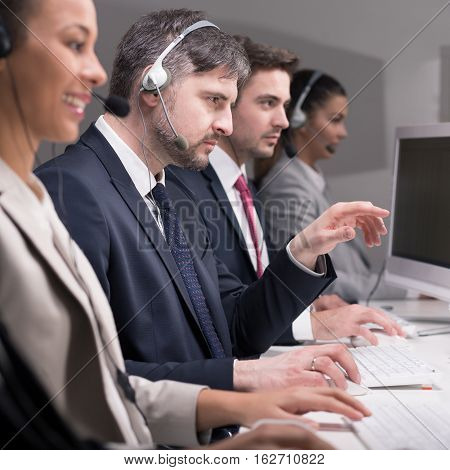Employees of call center are engrossed in work at the desk