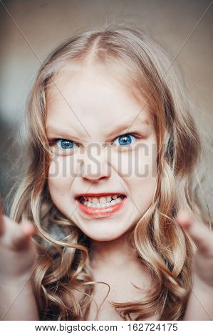 Portrait of angry capricious little girl shouting