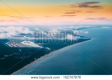 Western Dvina Flows Into The Baltic Sea. River Divides The Northern And Kurzeme District Of Riga, Latvia. View From Airplane Window. Sunset Sunrise Over Gulf Of Riga, Bay Of Riga, Or Gulf Of Livonia
