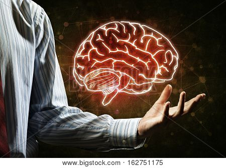 Close up of businessman hand holding brain in palm