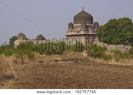 MANDU, MADHYA PRADESH, INDIA - NOVEMBER 18, 2008: Darya Khan's tomb in the hilltop fortress of Mandu. Building with central dome and a smaller dome on each corner in a walled compound. 16th Century AD