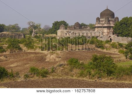 MANDU, MADHYA PRADESH, INDIA - NOVEMBER 18, 2008: Darya Khan's tomb in the hilltop fortress of Mandu. Building with central dome and a smaller dome on each corner in a walled compound. 16th Century AD