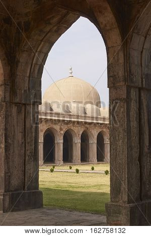 MANDU, MADHYA PRADESH, INDIA - NOVEMBER 18, 2008: Inner courtyard and covered prayer hall of the ancient mosque of Ashrafi Mahal Mosque in the hilltop fortress of Mandu in Madya Pradesh, India. 15th Century AD